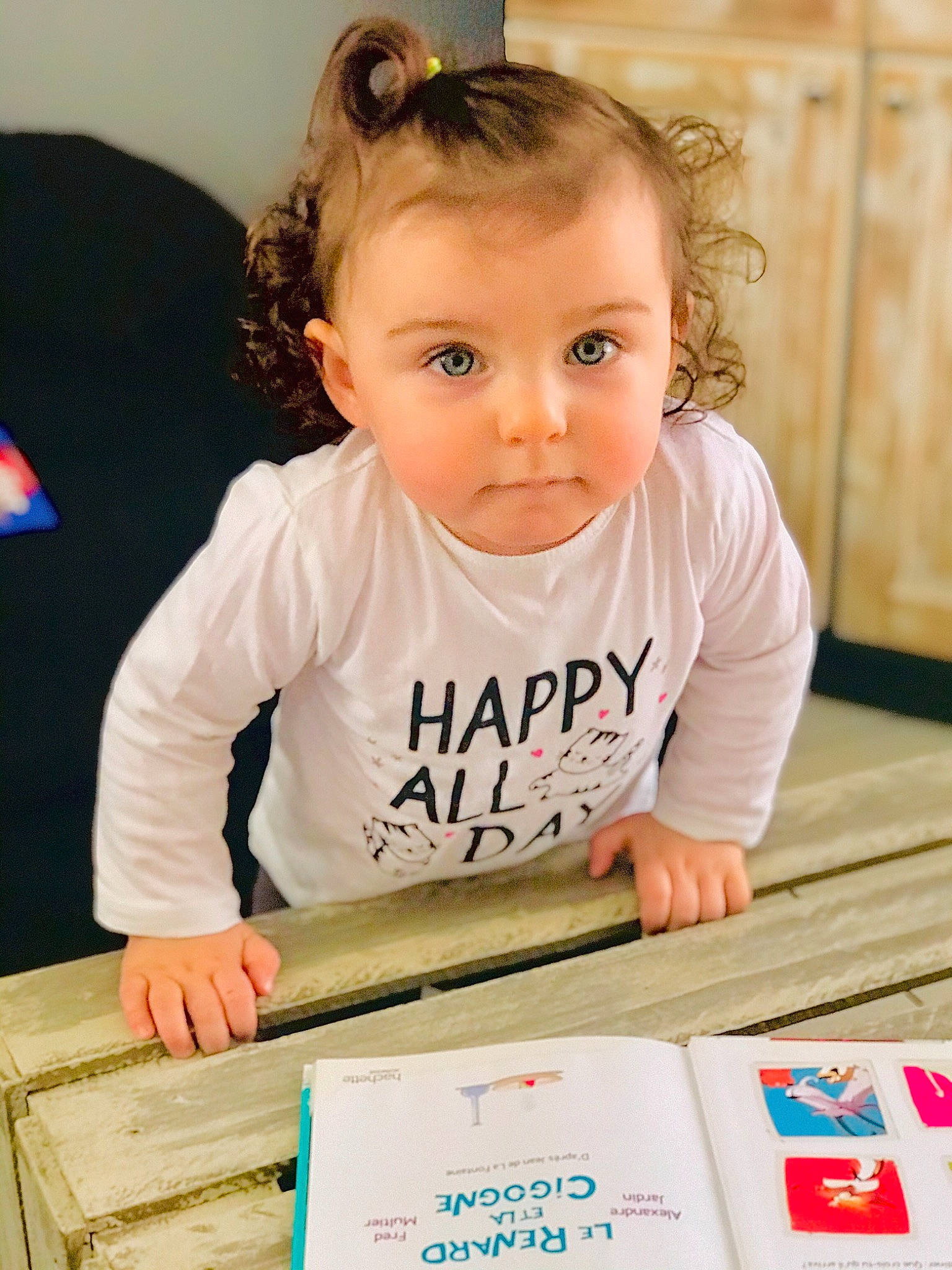 Alyx participe au concours pour gagner de l'argent avec cette photo : arm, baby, baby_toddler_clothing, cheek, child, dress, eye, eyelash, flooring, font, fun, hair, happy, person, rectangle, skin, sleeve, t_shirt, table, toddler