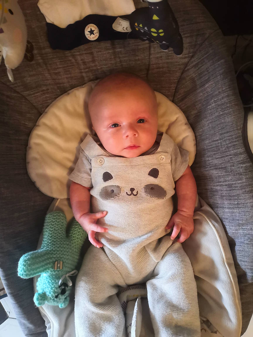 John is registered to the contest to win money with this photo: baby, baby_in_car_seat, baby_products, cheek, child, head, person, product, sitting, skin, toddler, toy