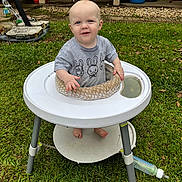 Alex joined the competition — help win amazing prizes! baby, child, walker, grass, outdoor, porch, chair, baby_bottle, shirt, smile, face, foot, toy, person, greenery, yard, playtime, happy, cute, casual