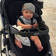 Maverick joined the competition — help win amazing prizes! baby, stroller, cap, child, foot, barefoot, black_stroller, graco, striped_shirt, sitting, infant, cute, playful, expression, clothing, seatbelt, blanket, indoors, floor, person