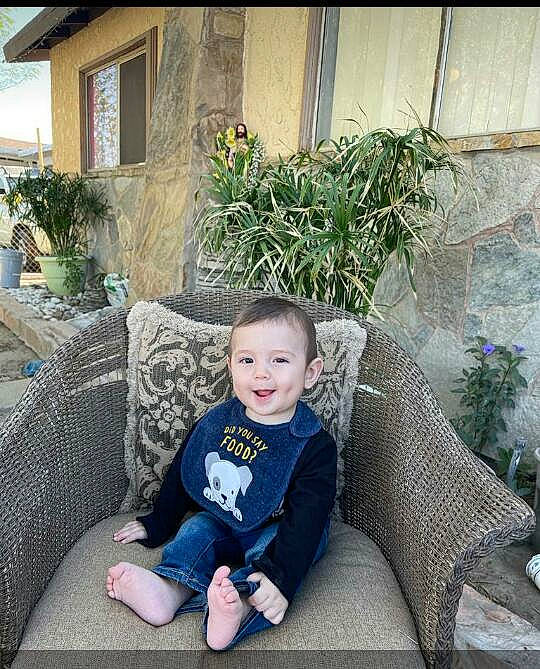 Osman is registered to the contest to win money with this photo: baby_toddler_clothing, chair, comfort, couch, flooring, flowerpot, garden, grass, home, houseplant, joy, leaf, leisure, living_room, outdoor_furniture, person, plant, sitting, smile, t_shirt