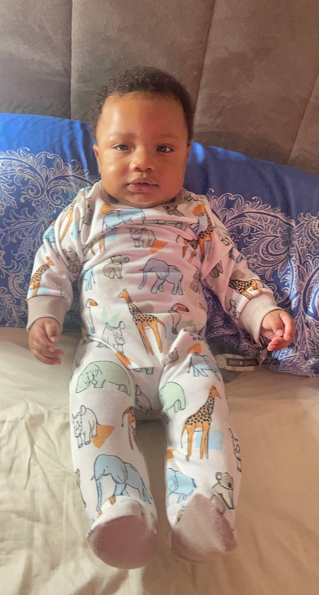 Kairo is registered to the contest to win money with this photo: baby, baby_toddler_clothing, cheek, child, comfort, face, finger, flooring, head, human_leg, knee, linens, mouth, person, skin, sleeve, smile, textile, thigh, toddler
