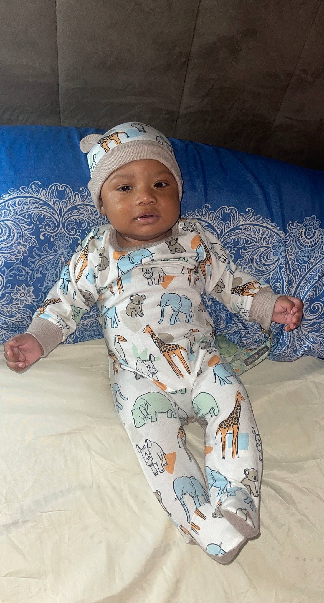 Kairo is registered to the contest to win money with this photo: baby, baby_products, baby_safety, baby_toddler_clothing, baseball_cap, cap, child, comfort, face, flooring, fun, head, headwear, linens, pattern, person, room, sitting, sleeve, textile