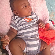 Asaël participe au concours pour gagner de l'argent avec cette photo : baby, infant, onesie, stripes, tiger_patch, pink_blanket, orange_towel, socks, chubby_legs, face, hand, car_seat, bedding, fabric, indoor, wall_texture, portrait, relaxed, looking_away, cute