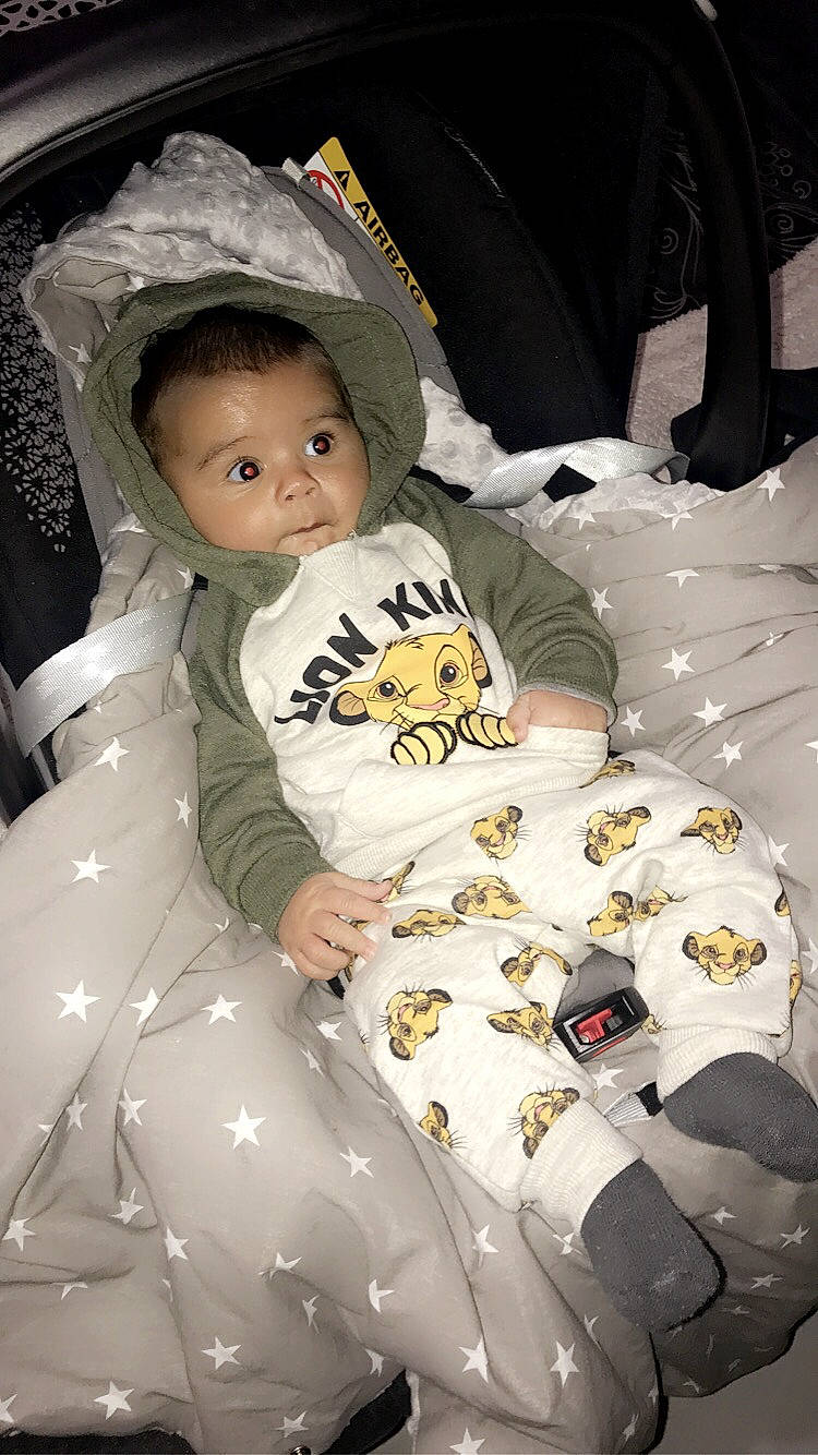 Tiago participe au concours pour gagner de l'argent avec cette photo : baby, baby_carriage, baby_products, baby_toddler_clothing, car_seat, child, comfort, fun, hat, headgear, linens, pattern, person, personal_protective_equipment, room, sitting, sleeve, smile, textile, toddler