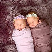 Leslie And Lettie is registered to the contest to win money with this photo: baby, newborn, twin_babies, swaddled, sleeping, headband, floral_headband, fur_blanket, plush, studio_photography, portrait, cute, pink, mauve, blanket, soft_texture, peaceful, indoor, two_people, infant