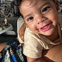 toddler, child, smiling, face, eyes, curly_hair, indoor, living_room, couch, cushion, baby_toys, person, human_arm, clothing, holding, closeup, happy, skin, portrait, infant