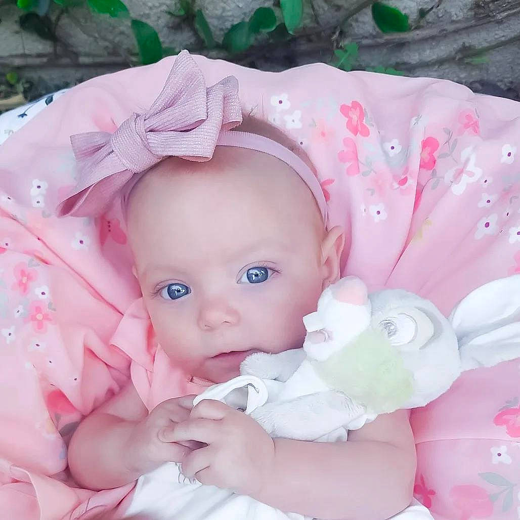 Presley is registered to the contest to win money with this photo: baby, baby_products, baby_toddler_clothing, cheek, child, fashion_accessory, grass, hair_accessory, happy, headgear, iris, lip, pattern, person, petal, pink, purple, skin, sleeve, toddler
