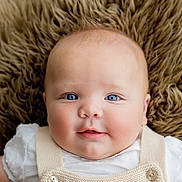 Michael is registered to the contest to win money with this photo: baby, infant, portrait, face, blue_eyes, smiling, cute, soft_texture, fur_background, clothing, knitwear, white_shirt, close_up, rosy_cheeks, skin, person, child, newborn, happy, innocence