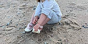 Aryanna participe au concours pour gagner de l'argent avec cette photo : beach, casual_clothing, child, daylight, footprints, grass, happy, nature, outdoor, person, playful, portrait, rocks, sand, shoe, sitting, small_rocks, smiling, toddler, young_child