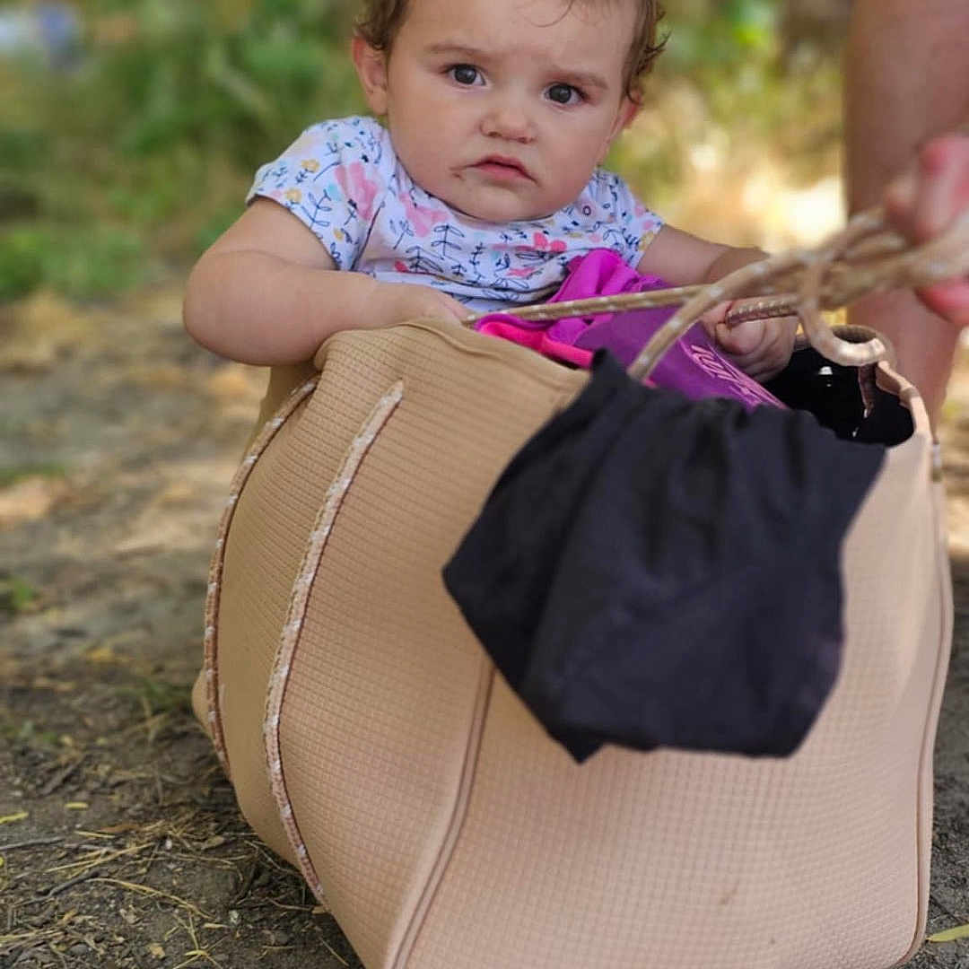 Ala joined the competition — help win amazing prizes! bag, child, clothing, curious, daylight, expression, face, greenery, ground, hand, nature, outdoor, person, playful, puzzled, sitting, small_child, summer, toddler, young_child