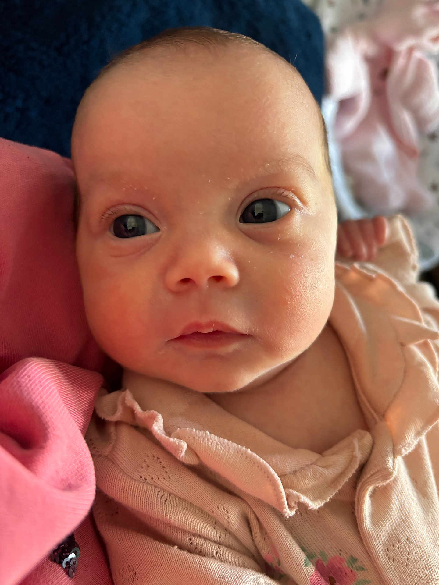 Stevie is registered to the contest to win money with this photo: baby, infant, face, eyes, skin, clothing, pink, fabric, soft, closeup, portrait, cute, newborn, child, person, young, indoors, resting, expression, ruffles
