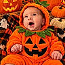 Maverick is registered to the contest to win money with this photo: baby, child, infant, pumpkin_costume, halloween, jack_o_lantern, autumn, orange, costume, portrait, sitting, smiling, surprised, face, indoor, blanket, plaid, festive, seasonal, cozy