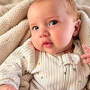Maverick joined the competition — help win amazing prizes! baby, child, infant, portrait, face, eyes, wide_eyed, calm, clothing, cream_outfit, knitwear, blanket, soft_blanket, cozy, indoors, close_up, sitting, hand, warm_lighting, photography