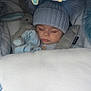 baby, sleeping, knit_hat, blanket, plush_toy, blue, cozy, car_seat, child, infant, cute, soft_toys, peaceful, nap, warm_clothing, mobile, indoors, resting, cushion, portrait