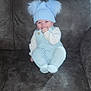 Aaron-Jay joined the competition — help win amazing prizes! baby, child, blue_hat, knitted_outfit, pom_poms, sitting, couch, indoor, red_eye, infant, cute, hand_in_mouth, furniture, soft_texture, cozy, portrait, young_child, warm_clothing, smiling, person
