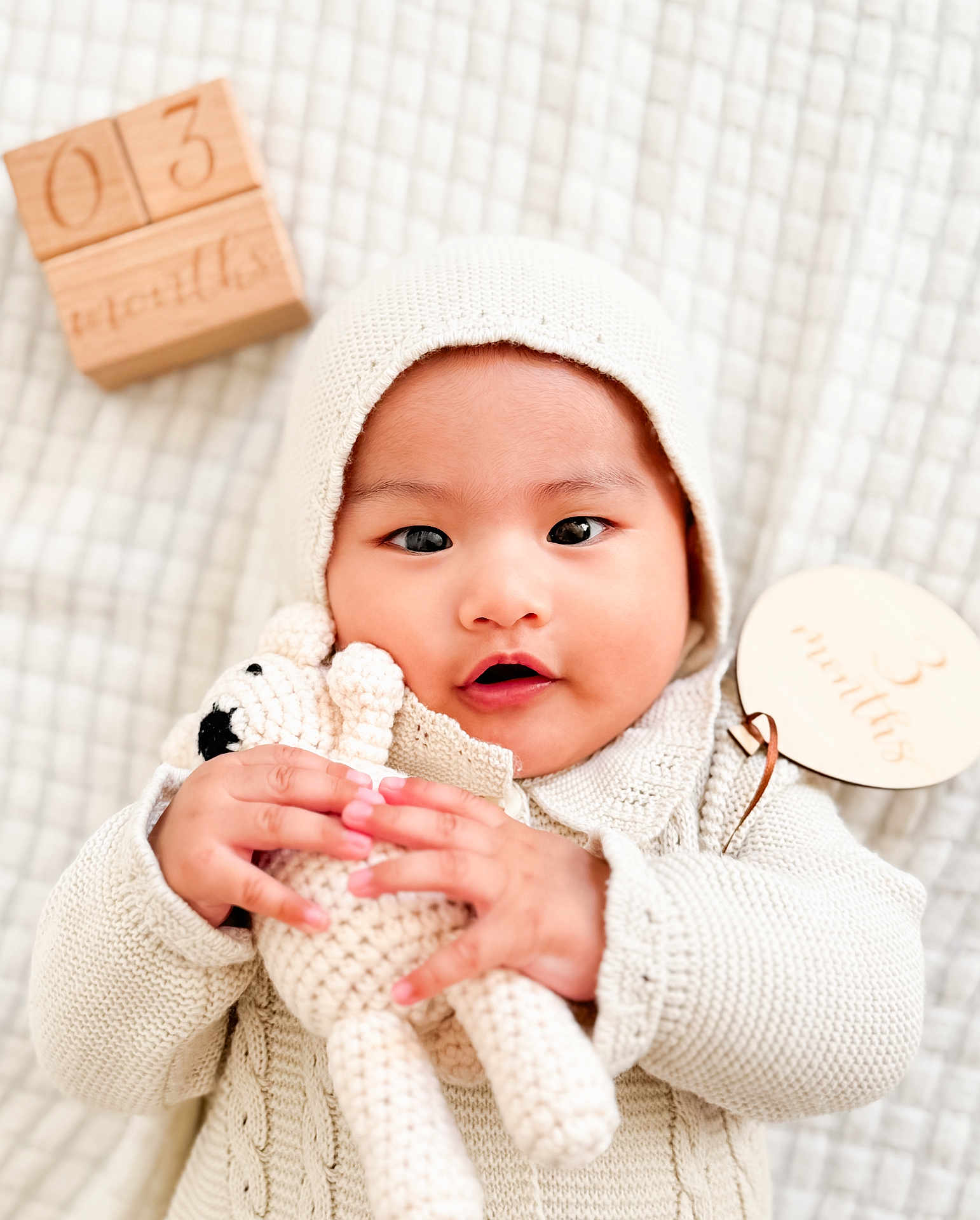Sardonyx Elijah is registered to the contest to win money with this photo: baby, infant, knit_clothing, bonnet, crocheted_toy, teddy_bear, wooden_blocks, 3_months, blanket, soft_texture, cute, child, portrait, hands, face, lying_down, cozy, warm, indoor, newborn