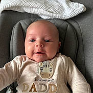 Morgan joined the competition — help win amazing prizes! baby, infant, face, smile, onesie, clothing, seat, blanket, cute, expression, child, indoor, portrait, person, text, zebra_patch, happy, cozy, young, closeup