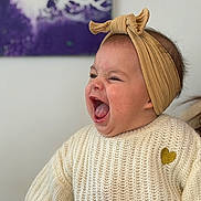 Romane a rejoint le concours — aidez-le/la à gagner de superbes lots ! baby, child, laughing, knitted_sweater, headband, heart_patch, mouth_open, happy, portrait, indoor, person, cute, infant, smiling, apparel, face, skin, hair, expression, background