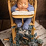 Sangsehang is registered to the contest to win money with this photo: baby, sleeping, blue_knit_outfit, wooden_chair, pillow, potted_plants, greenery, indoor, cozy, peaceful, child, portrait, floor_rug, decor, relaxation, infant, knitwear, hands, face, head