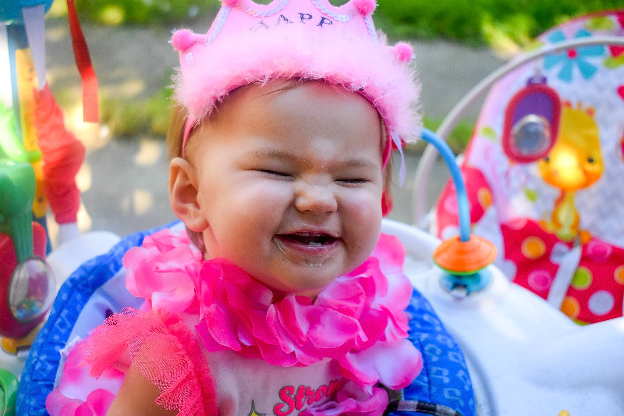 Kiana is registered to the contest to win money with this photo: baby, baby_laughing, birthday, cheek, child, face, facial_expression, fun, hair_accessory, happy, headgear, laugh, party, party_supply, person, pink, play, smile, toddler