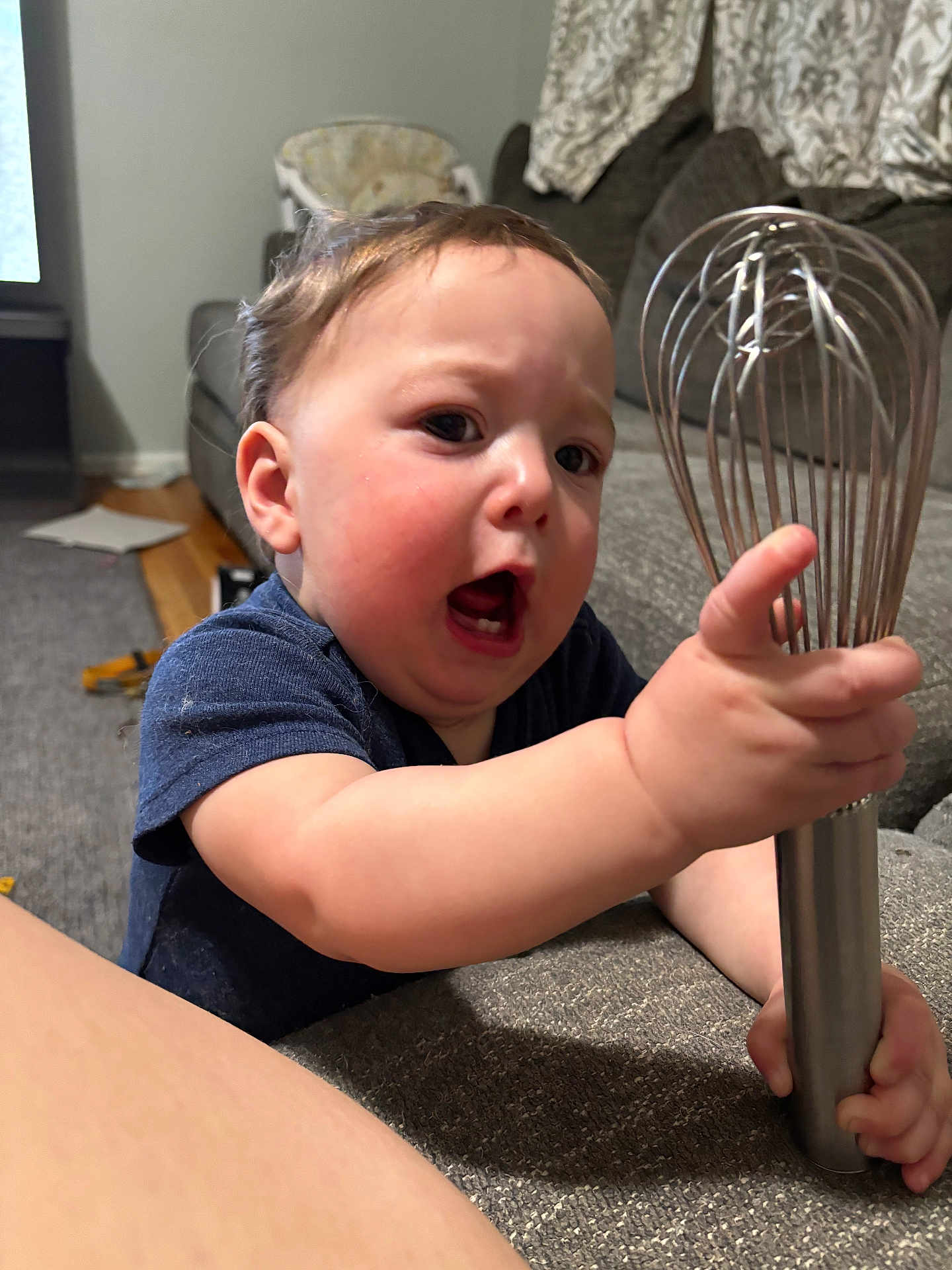 Jackson joined the competition — help win amazing prizes! baby, child, whisk, kitchen_tool, expression, face, chubby_cheeks, indoor, couch, carpet, clothing, short_sleeve, person, hand, grip, living_room, curtains, furniture, hair, tongue_out