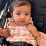 baby, child, car_seat, pink, hair_clip, flower, curious, infant, seatbelt, clothing, blanket, face, portrait, young_child, cute, sitting, indoors, closeup, person, button