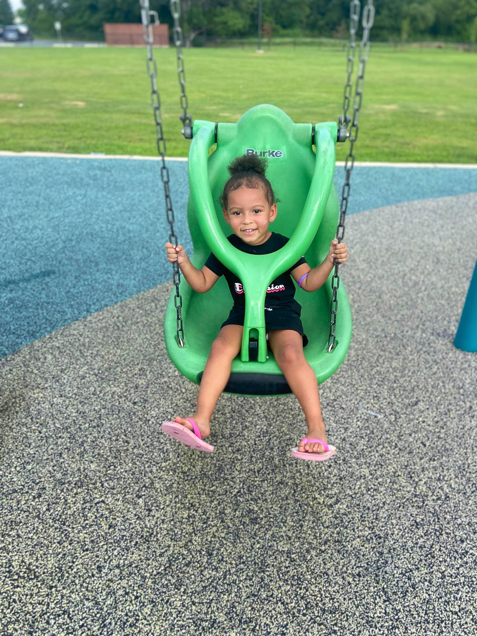 Milani is registered to the contest to win money with this photo: asphalt, baby, baby_toddler_clothing, city, electric_blue, fun, grass, grass_family, happy, joy, lawn, leisure, outdoor_play_equipment, people_in_nature, person, plant, playground, recreation, smile, swing