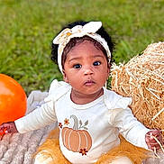 Amiri joined the competition — help win amazing prizes! toddler, child, baby, outdoor, grass, blanket, pumpkin, balloon, hay_bale, headband, curly_hair, fall, seasonal, cute, portrait, sitting, autumn, clothing, nature, festive