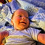 Tristan is registered to the contest to win money with this photo: baby, smiling, infant, blanket, pattern, bottle, clothing, happy, face, person, child, bedroom, home, comfort, cute, reaching, soft, lying_down, indoor, young