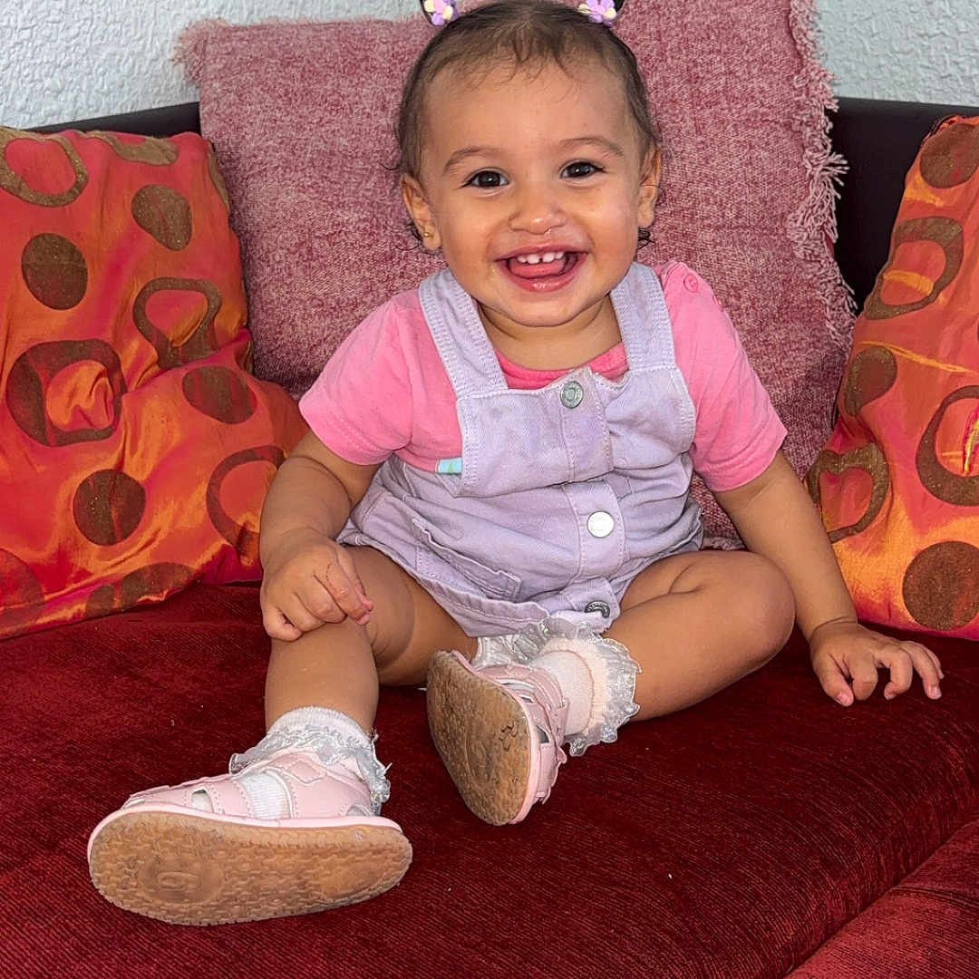 Zouleikha a rejoint le concours — aidez-le/la à gagner de superbes lots ! baby, child, clothing, couch, cute, face, footwear, hair, hair_accessory, happy, home, indoors, person, pillow, pink, plush, sitting, smile, sock, toddler