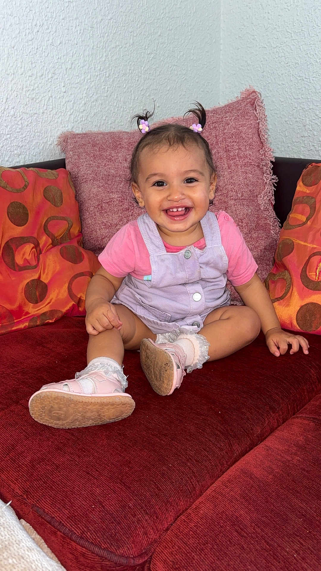 Zouleikha a rejoint le concours — aidez-le/la à gagner de superbes lots ! toddler, child, smile, happy, sitting, couch, pillow, indoors, hair, clothing, footwear, sock, face, person, pink, cute, baby, home, hair_accessory, plush