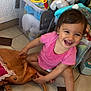 Zouleikha a rejoint le concours — aidez-le/la à gagner de superbes lots ! toddler, child, smiling, pink_clothing, brown_leather_bag, baby_bottle, tiles, toys, plastic_container, stuffed_animals, floor, indoor, happy, playful, curly_hair, baby, person, candid, sitting, cute
