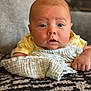 baby, infant, blanket, cloth, hand, face, eyes, indoor, carpet, person, skin, yellow_clothing, texture, soft, cute, lying_down, closeup, portrait, expression, child