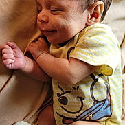 Vincent is registered to the contest to win money with this photo: baby, infant, sleeping, smiling, onesie, yellow_stripes, cartoon_print, hand, fist, ear, face, skin, blanket, soft, cozy, cute, newborn, sock, legs, resting