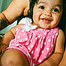 Ciara is registered to the contest to win money with this photo: baby, child, smiling, pink_clothing, polka_dots, cute, portrait, indoor, happy, person, infant, closeup, skin, face, eyes, hair, sitting, arm, adult, holding