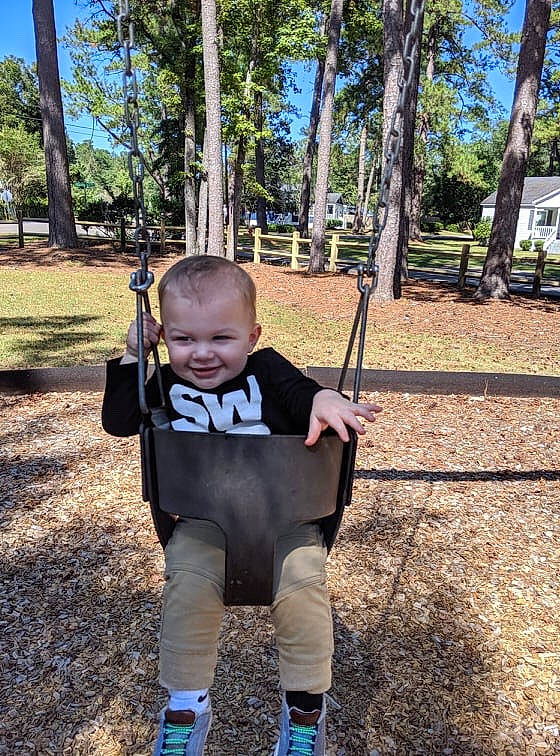 Grayson is registered to the contest to win money with this photo: child, joy, outdoor_play_equipment, person, plant, playground, public_space, recreation, swing, toddler, tree