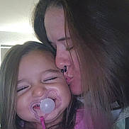 Novaleigh is registered to the contest to win money with this photo: child, woman, kiss, pacifier, smile, indoor, love, affection, hair, face, closeup, happy, family, bond, person, pink_clothing, nose_ring, long_hair, toddler, emotion