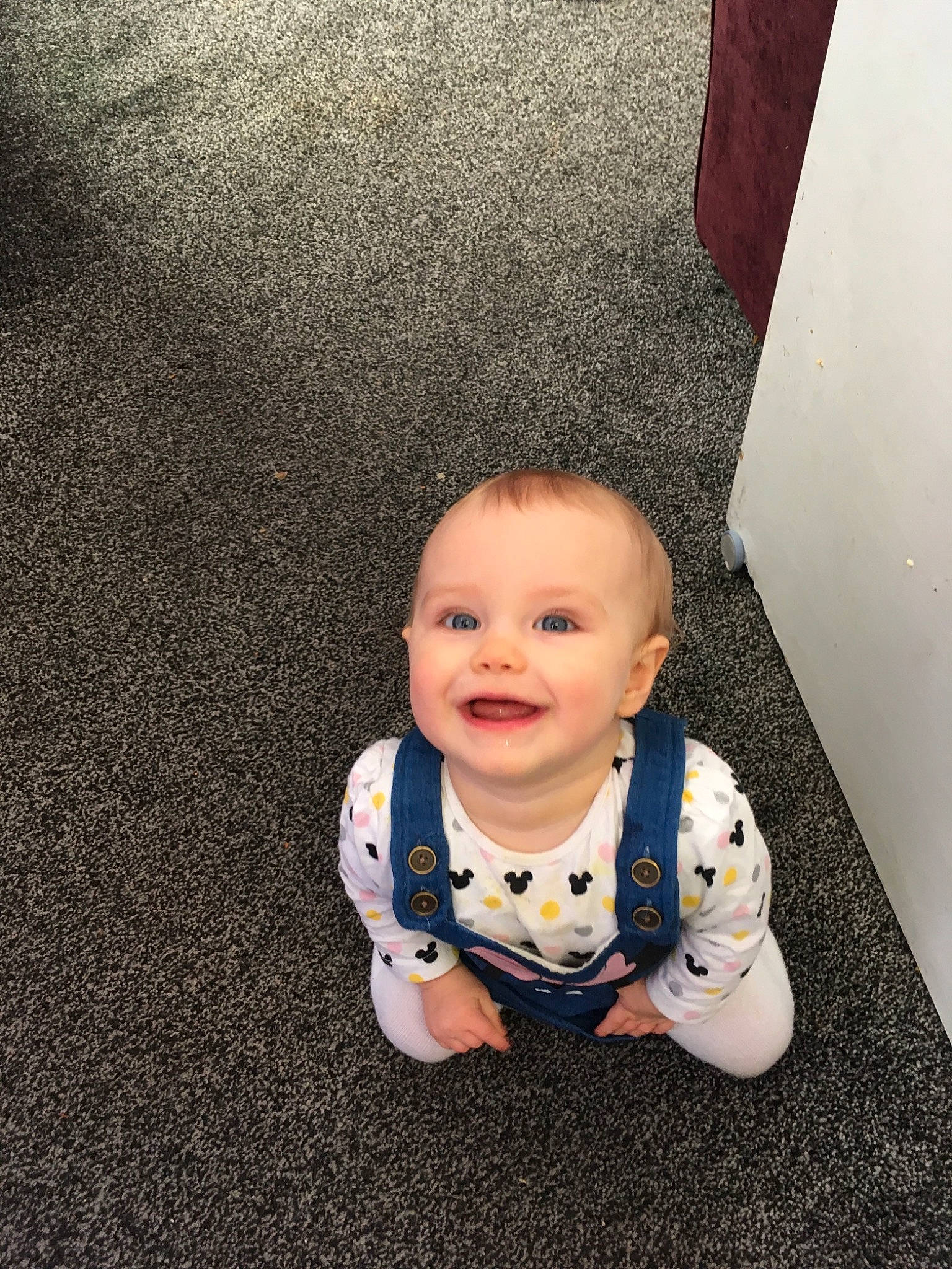 Olivia-rose is registered to the contest to win money with this photo: baby, cheek, child, electronic_device, eye, face, floor, flooring, head, person, photography, sitting, skin, smile, toddler