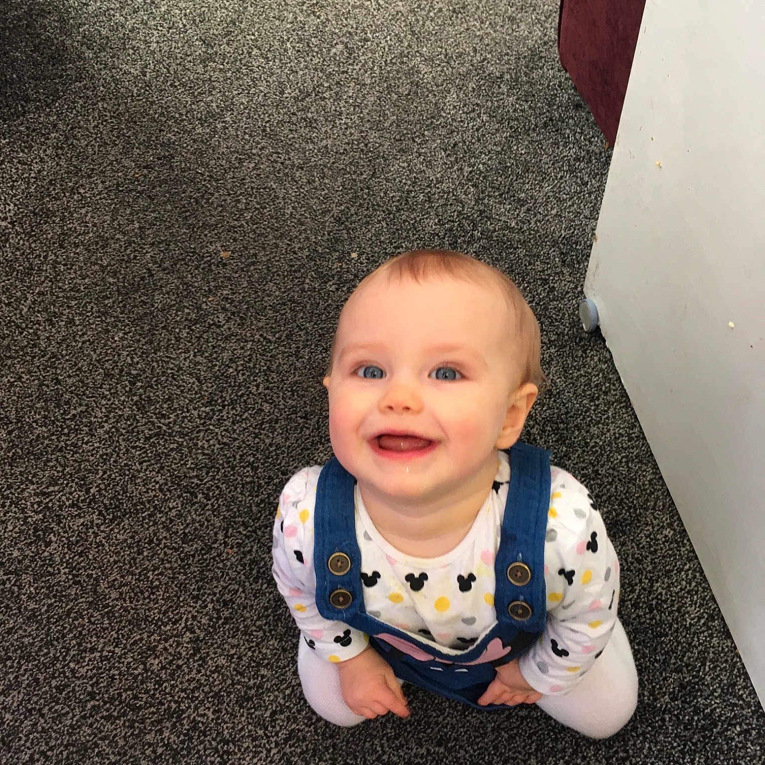 Olivia-rose is registered to the contest to win money with this photo: baby, cheek, child, electronic_device, eye, face, floor, flooring, head, person, photography, sitting, skin, smile, toddler