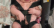 Luna is registered to the contest to win money with this photo: baby, child, car_seat, pink_clothing, headband, smiling, infant, safety_harness, cute, indoor, footwear, pacifier, floral_pattern, seatbelt, portrait, person, baby_girl, happy, hand, closeup