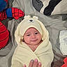 baby, towel, bed, blanket, diaper, hand, nail_polish, person, cute, infant, soft, wrapped, smile, indoors, fabric, plush, comfort, child, resting, cozy