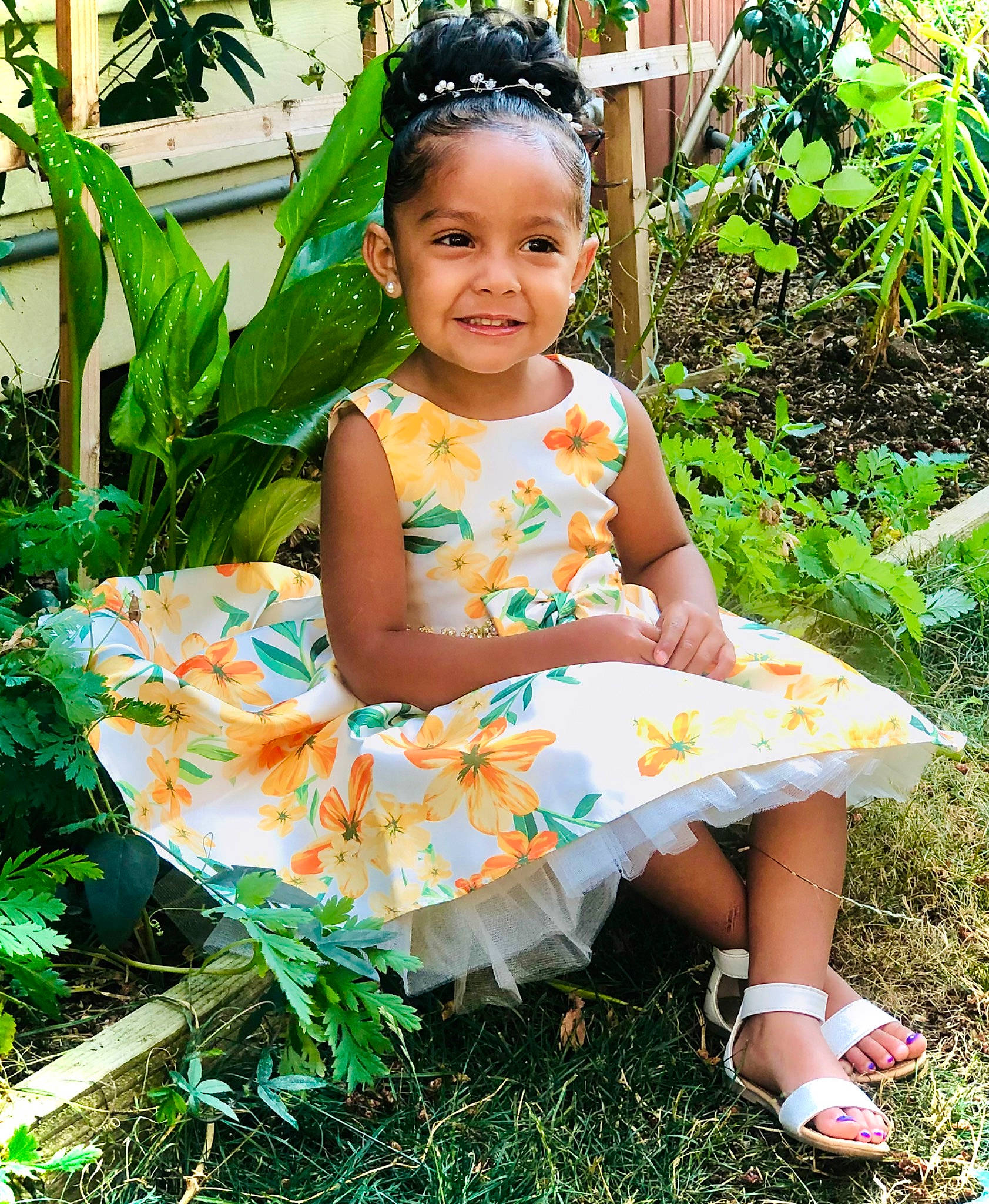 Milani is registered to the contest to win money with this photo: baby_toddler_clothing, child, clothing, day_dress, dress, event, fun, grass, green, hairstyle, happy, joy, leisure, pattern, people_in_nature, person, plant, sandal, sleeve, smile