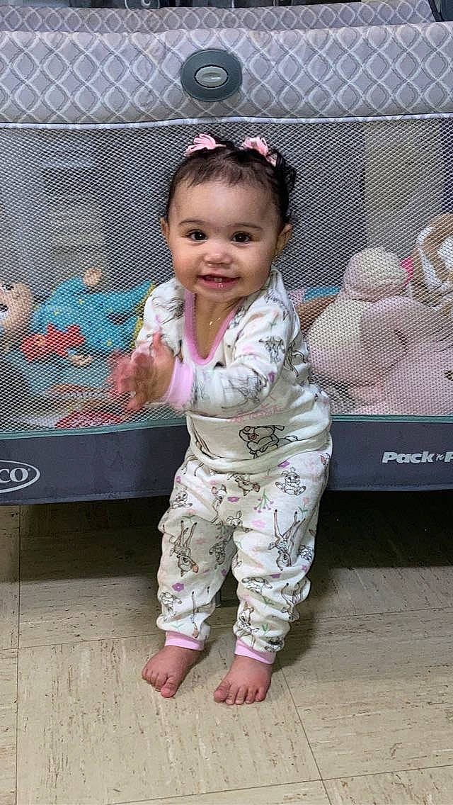 Octavia is registered to the contest to win money with this photo: baby, baby_toddler_clothing, barefoot, cheek, child, face, facial_expression, fun, gesture, hair, happy, leisure, magenta, person, pink, skin, sleeve, smile, thumb, toddler