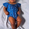 baby, infant, child, blue_clothing, headband, sandals, flower, blanket, soft, cute, adorable, smiling, portrait, indoor, fashion, footwear, person, lying_down, baby_girl, comfortable