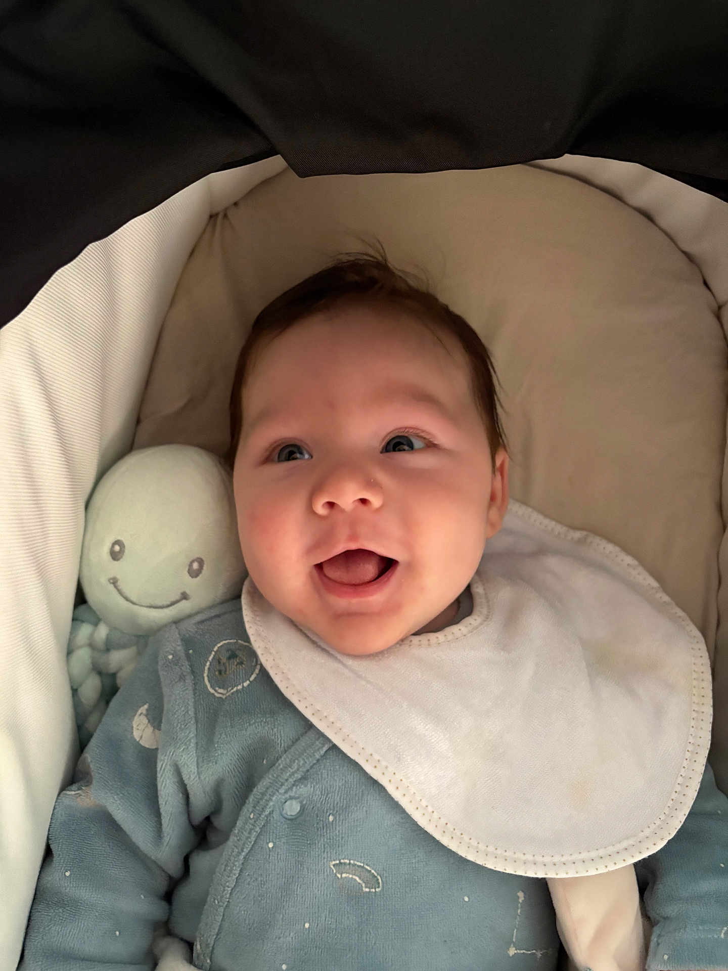 Jonah Mercier a rejoint le concours — aidez-le/la à gagner de superbes lots ! baby, infant, newborn, smiling, bib, onesie, plush_toy, octopus_toy, bassinet, stroller_linings, blanket, cozy, portrait, face, cheeks, eyes, mouth, happy, lying_down, clothing