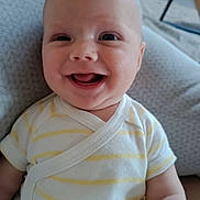 Iréné participe au concours pour gagner de l'argent avec cette photo : baby, infant, smiling, happy, onesie, clothing, face, head, skin, cute, child, portrait, seated, cushion, indoor, home, expression, human, person, cheerful