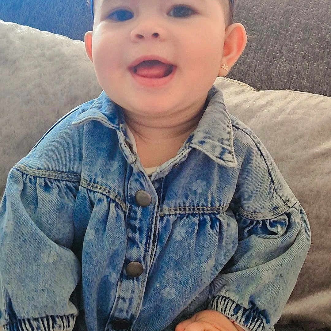 Mira a rejoint le concours — aidez-le/la à gagner de superbes lots ! baby, child, clothing, couch, cozy, cute, denim_jacket, earrings, face, hand, happy, headband, indoor, infant, long_sleeves, patterned_tights, pillows, portrait, sitting, smiling