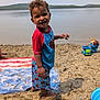 Zehri joined the competition — help win amazing prizes! child, toddler, beach, sand, water, lake, toy, bucket, towel, smiling, barefoot, summer, outdoor, play, clothing, curly_hair, elmo, happy, nature, daytime