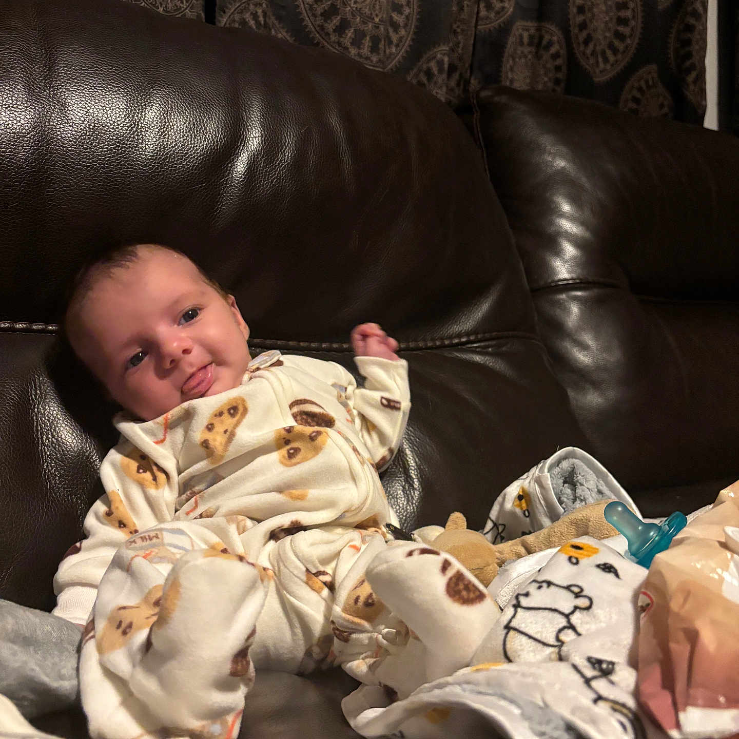 Jamaryon is registered to the contest to win money with this photo: baby, blanket, child, couch, cozy, curtain, cute, furniture, indoors, infant, leather, pacifier, pajamas, pattern, playful, portrait, relaxing, smiling, soft, tongue